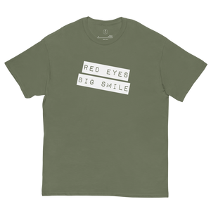 Covert Grin Tee in army green laid flat, showcasing the subtle 'Big Smile Red Eyes' design for the discerning fashion operative