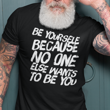 Load image into Gallery viewer, An older man exudes confidence and timeless cool, modeling a black t-shirt with bold white print, embodying the shirt&#39;s rebellious spirit.