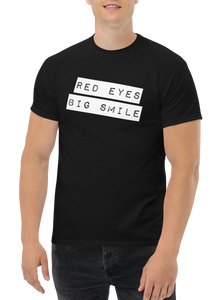 "Make a statement with our RED EYES BIG SMILE Classic Tee - Black T-shirt Male Model Mockup - Funny Weed Shirt: Spread Love and Compassion with RED EYES BIG SMILE Black