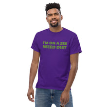 Load image into Gallery viewer, Model stands enigmatically in the purple Strains tee, a shadowy figure in the world of secret style operatives.